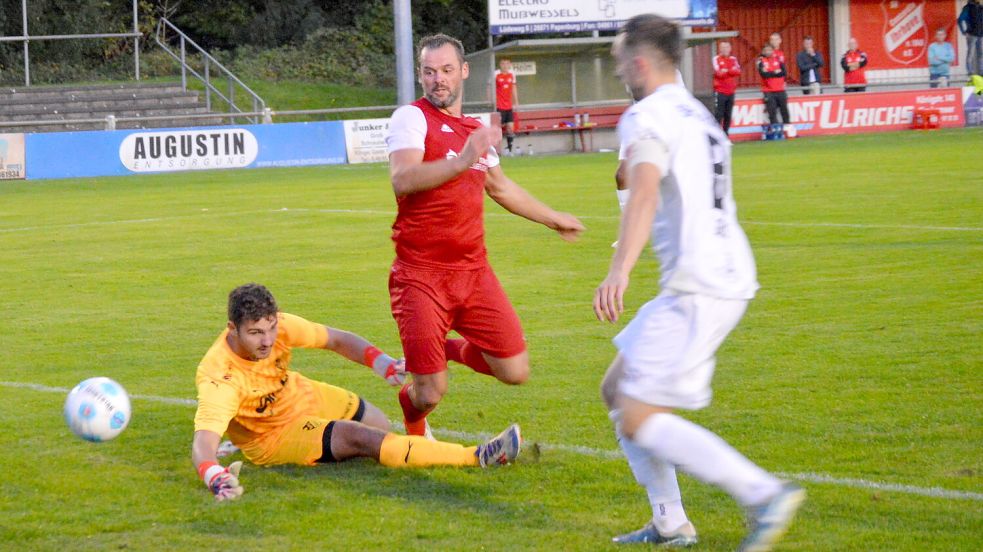 Auch in Unterzahl tauchten die Ihrhover (rote Trikots) immer wieder vor dem Tor des Auricher Schlussmanns Lars Küßner auf. Der Auricher Keeper verursacht in dieser Szene mit dem Foul an Peter Landel einen Elfmeter. Foto: Weers