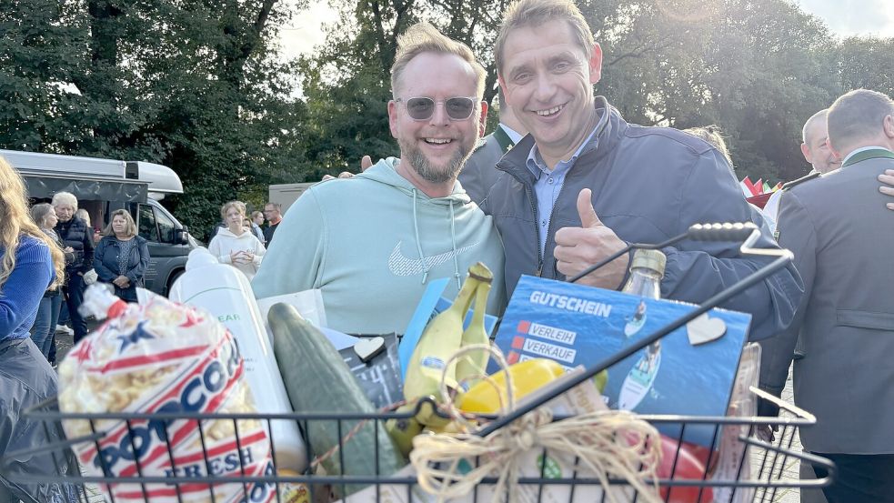Tosten Stephan von der Verwaltung (links) und Bürgermeister Heinz Trauernicht zeigen: Ein Präsentkorb wie dieser soll bei den kommenden Märkten verlost werden. Foto: Heinig