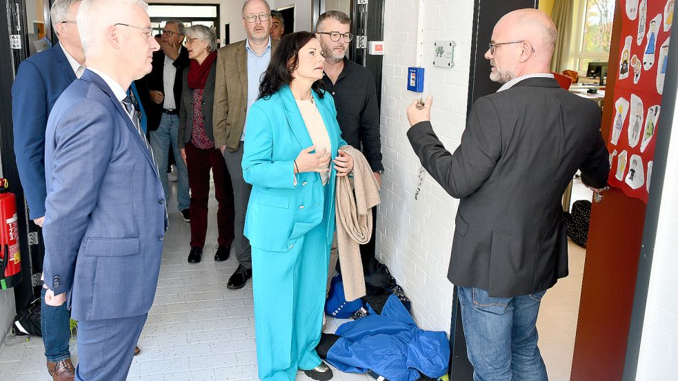 Hereinspaziert: Schulleiter Karsten Gövert öffnet die Tür zu einem der Klassenräume. Die Gäste, darunter Landrat Matthias Groote (links) und die CDU-Bundestagsabgeordnete Gitta Connemann (vorne), sind gespannt. Foto: Stromann