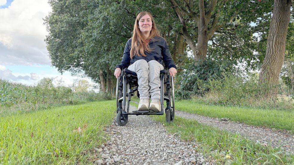 Die vielen dickeren Schottersteine auf dem Ostfriesland-Wanderweg bereiten Lara Brink, die auf einen Rollstuhl angewiesen ist, Probleme. Wenn dann noch in der Mitte des Weges das Gras aus dem Schotter wächst, wird es schwierig für die 25-Jährige, dort mit dem Rollstuhl zu fahren. Auf diese Probleme hatte die Rollstuhlfahrerin bei einem Vor-Ort-Termin mit dieser Zeitung im September hingewiesen. Foto: Ammermann