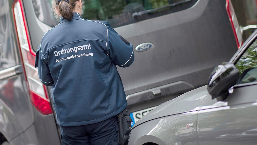 Eine Mitarbeiterin des Ordnungsamtes kontrolliert auf diesem Symbolfoto parkende Fahrzeuge. Symbolfoto: Skolimowska/dpa