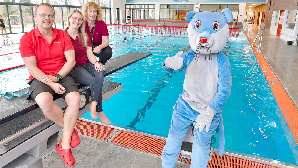 Holger van der Slyk (von links), verantwortlich für die Schwimmschule, sowie die Geschäftsführerinnen Lisa Kesse und Anja Buse freuen sich mit dem Maskottchen Pietje über das fünfjährige Bestehen. Fotos: Ortgies