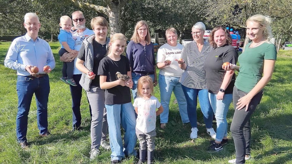 Fühlen sich dem Apfel verbunden: Landrat Matthias Groote, Johannes Bolland mit Enkel Leo, Miriam Wagner, Feenia-Faylinn Tausendfreund mit Seramerküken Helene, Malin Block, Janneke Groote, Britta de Buhr-Hollatz, Birgit Lammers, Kim Müller. (vorne) Kalea-Talisya Tausendfreund. Foto: Scherzer