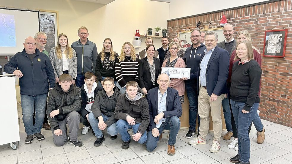 Im Beisein von Eltern, Schülern und Lehrkräften überreichte Frank Happe vom Wirtschaftsförderkreis Harlingerland (vierter von rechts) das Gütesiegel an Lehrerin Simone Robbers (stehend, siebte von links). Foto: Schule am Osterfehn