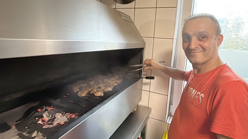Osman Gökalp arbeitet am Holzkohlegrill.