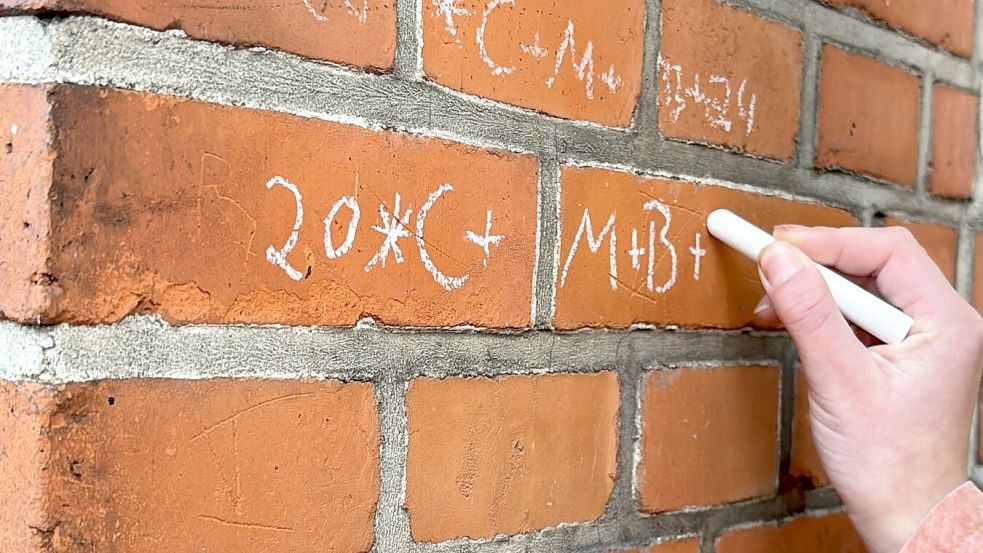 Mit Kreide schrieb Famke Schmidt den Segen an die Hauswand des GA-Gebäudes. Foto: Janßen