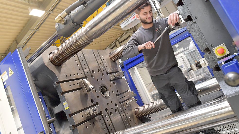 Mitarbeiter Selim Kelmedi steht in der größten Maschine von LMB Kunststofftechnik. Foto: Ortgies