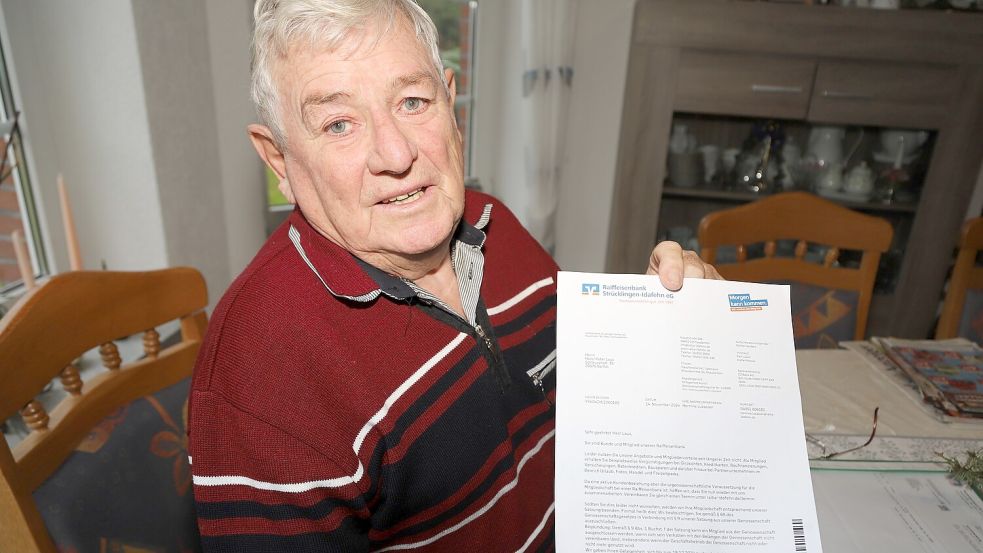 Hans Peter Laus zeigt das Schreiben, das er von der Raiffeisenbank Strücklingen-Idafehn erhalten hat. Foto: Passmann