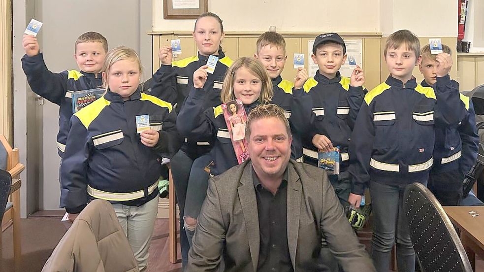 Mädchen und Jungen der Ihrhover Kinderfeuerwehr haben die Gewinnummern der Weihnachtsverlosung des HGV Ihrhove gezogen. Mit im Bild ist der HGV-Vorsitzende Holger Schütte zu sehen. Foto: HGV Ihrhove