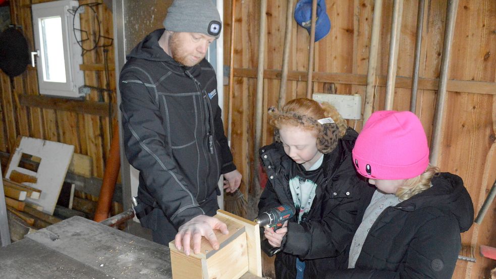 Unter Anleitung ihres Vaters Daniel durften die Schwestern Emma (Mitte) und Sarah Janssen (rechts) beim Nistkastenbau selbst Hand anlegen. Foto. Weers