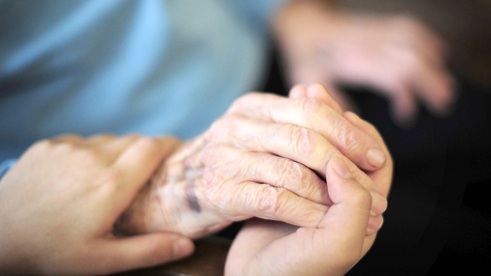 Eine Pflegekraft hält in einem Seniorenheim die Hand einer Bewohnerin. In Niedersachsen wächst die Zahl der Pflegebedürftigen. Foto: DPA/Daniel Reinhardt