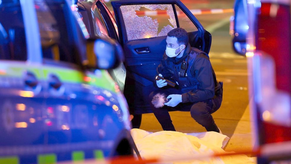 Ein Beamter der Polizei untersucht den Tatort. Foto: Christoph Reichwein/dpa