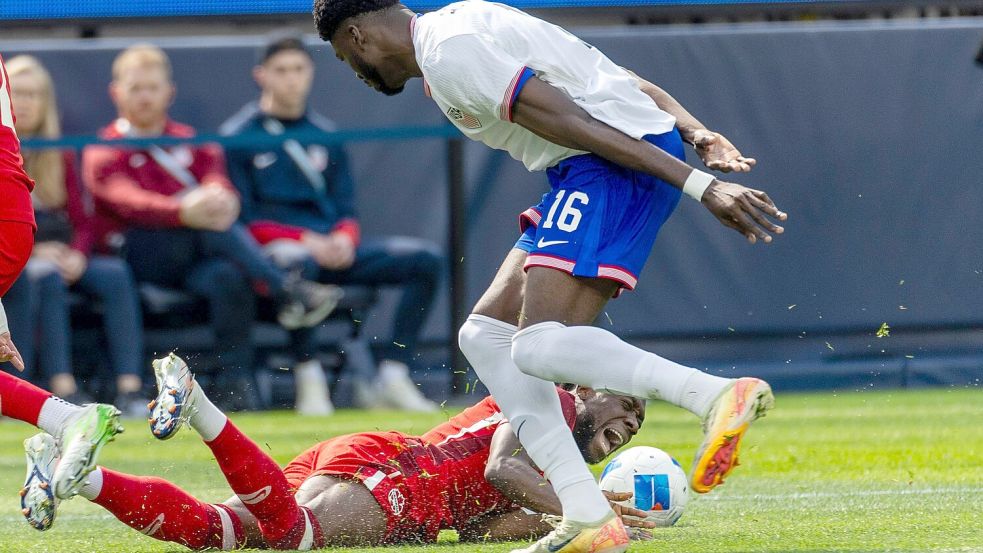 Alphonso Davies (unten) verletzte sich im Länderspiel gegen die USA. Foto: Ringo Chiu/ZUMA Press Wire/dpa
