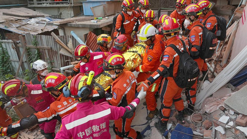 Rettungskräfte befreien einen Überlebenden unter Trümmern. Foto: Cai Yang/XinHua/dpa
