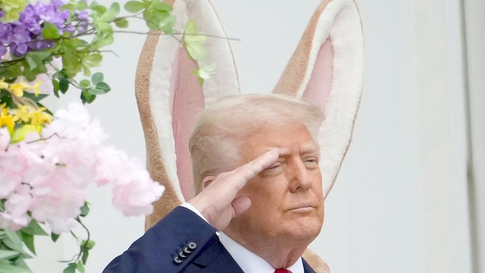 Donald Trump steht vor einem großen Osterhasen - und es sieht so aus, als hätte er sich die Ohren geliehen. Foto: Alex Brandon/AP/dpa