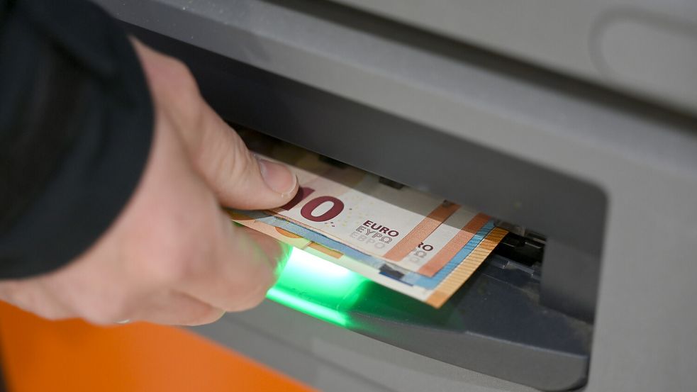 Ein Mann zieht Geldscheine aus dem Ausgabefach eines Geldautomaten. Symbolfoto: Elisa Schu/dpa