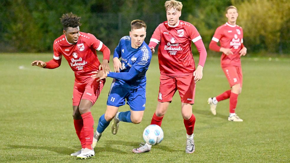 Die Holtriemer (Mitte Kim Böning) kamen beim FC Norden (rote Trikots) zu einem 2:2. Fotos: Doden, Blomberg