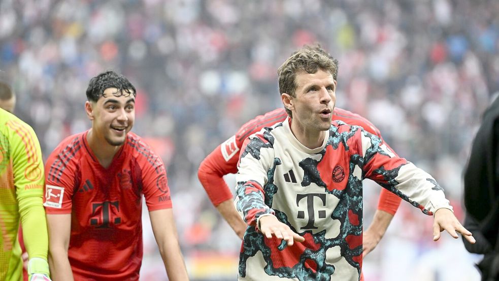 Thomas Müller (r) feiert vor der Bayern-Kurve in Leipzig. Foto: Elisa Schu/dpa
