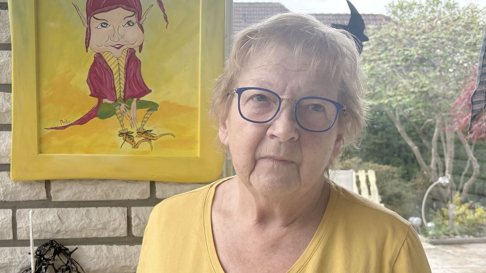 Marie Luise K. steht in ihrem Wohnhaus in Burlage vor einem von ihr selbst gemalten Bild.