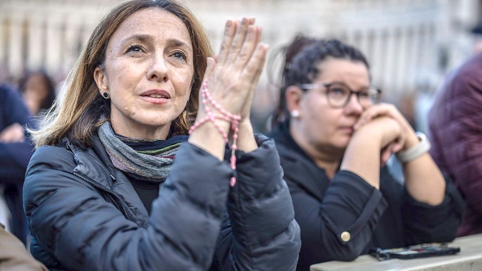 Manche nutzten die Wartezeit zum Beten. Foto: Oliver Weiken/dpa