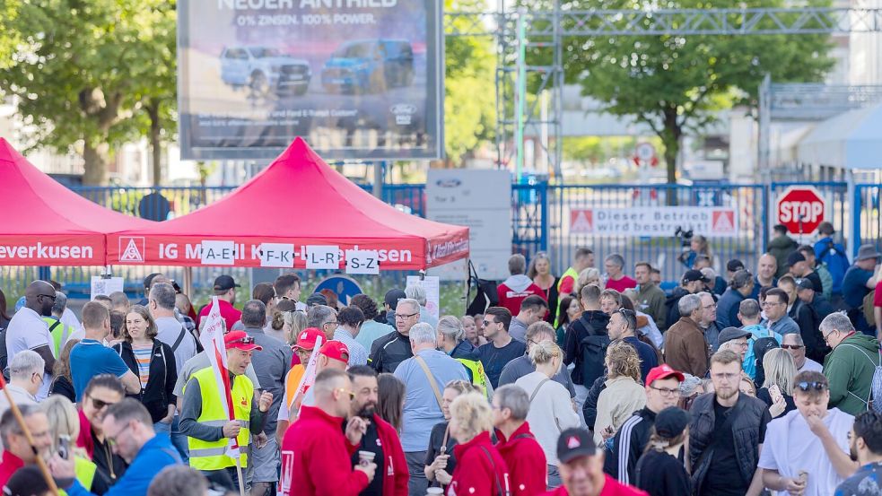 Statt zur Arbeit ins Werk zu gehen, bleiben die Streikenden vor dem Tor und holen sich Streik-Koupons ab. Foto: Rolf Vennenbernd/dpa