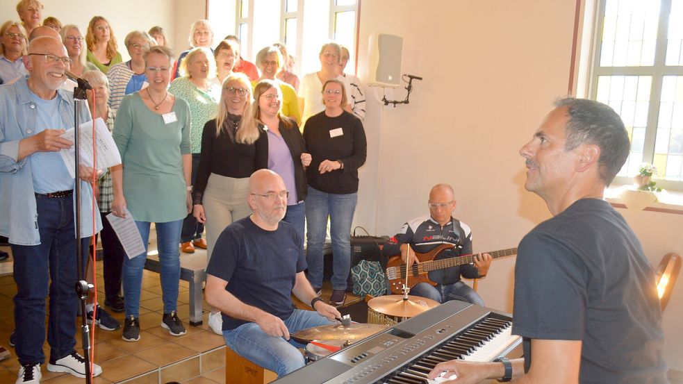 Musiklehrer Darius Rossol (rechts), begleitet von den Musikern Max Hentschel (Schlagzeug) und Tom Götz (Bass) bildeten zusammen mit 85 musikbegeisterten Frauen und Männern einen gemeinsamen Chor beim Gospel-Workshop in Ihrhove. Foto: Holger Weers