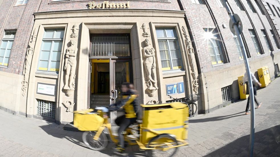 Eine Briefträgerin fährt an einer Postfiliale vorbei - vielleicht ist auch sie eine Beamtin? Foto: Wolf von Dewitz/dpa