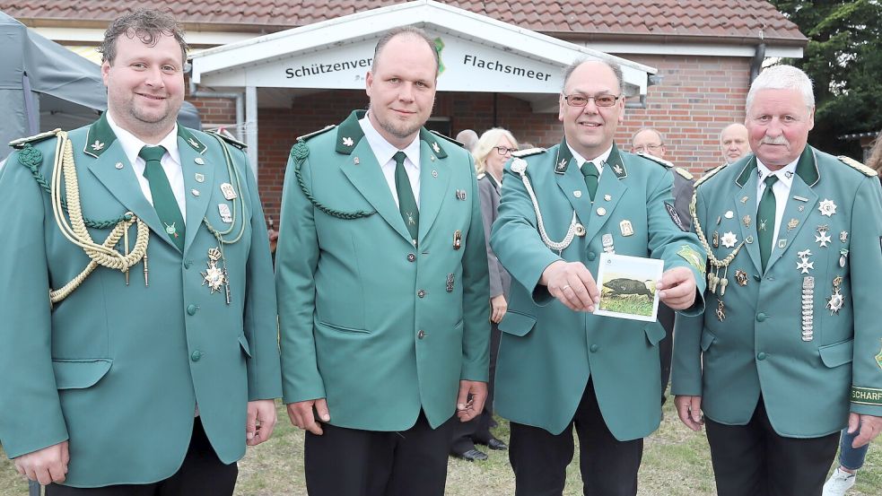 Dennis Steinhorst (links) und Arno Woortmann (rechts) vom Schützenverein Flachsmeer präsentieren den neuen Blasrohrkönig Lars Frerichs (zweiter von links) und König Thomas Träger.