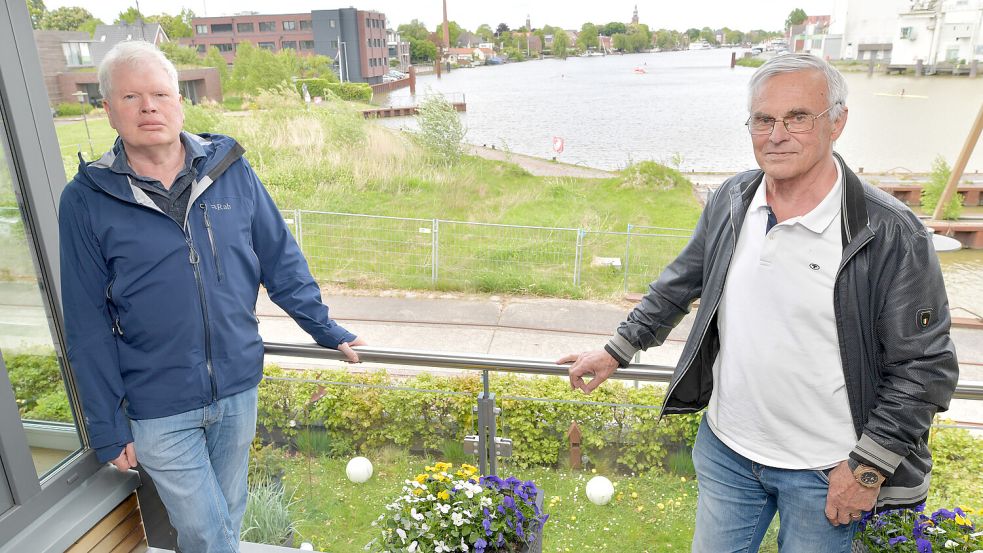 Leo Büchter (links) steht mit seinem Nachbarn Hans-Georg Petershöfer auf seinem Balkon im Stadthaus. Im Hintergrund ist die Fläche zu sehen, wo das „Bootshaus“ entstehen soll. Foto: Klaus Ortgies