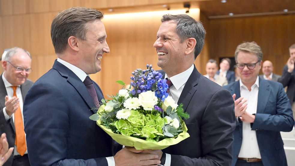 Da waren sie noch herzlich miteinander: Olaf Lies (SPD, rechts) erhält am Dienstag nach seiner Wahl zum Ministerpräsidenten einen Blumenstrauß von Sebastian Lechner, dem CDU-Fraktionsvorsitzenden im Landtag. Einen Tag später hagelt es dann Kritik. Links im Bild beäugt Ex-Ministerpräsident Stephan Weil (SPD) die Szenerie. Foto: dpa/Julian Stratenschulte