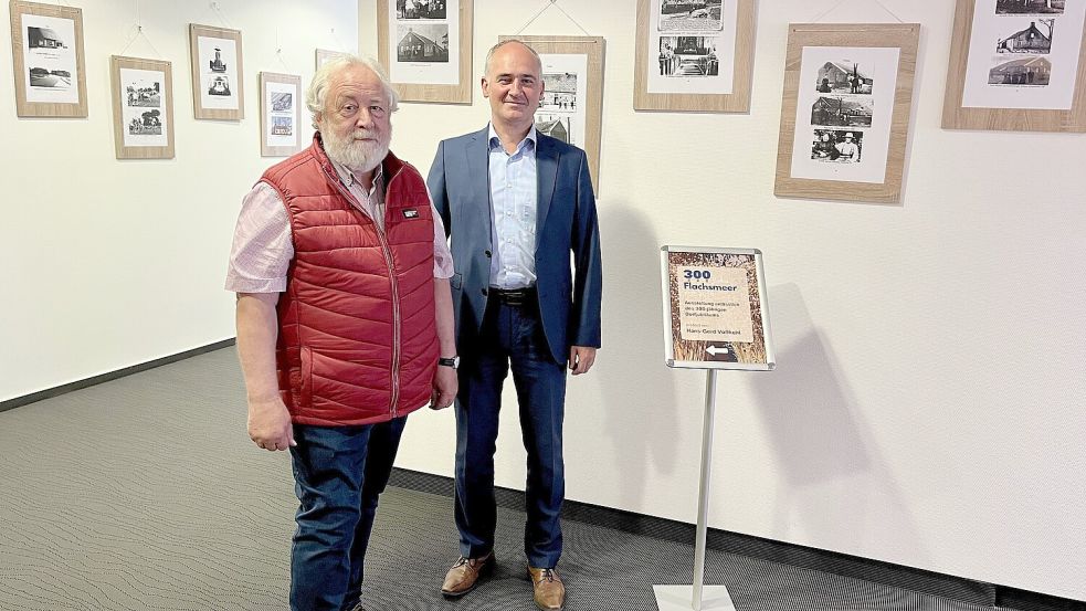 Hans Gerhard Voßkuhl und Matthias Beekmann (Vorstand Raiffeisenbank Flachsmeer) vor ausgestellten Bildern zur aktuellen Ausstellung: Foto: Raiba/ Kerstin Janssen