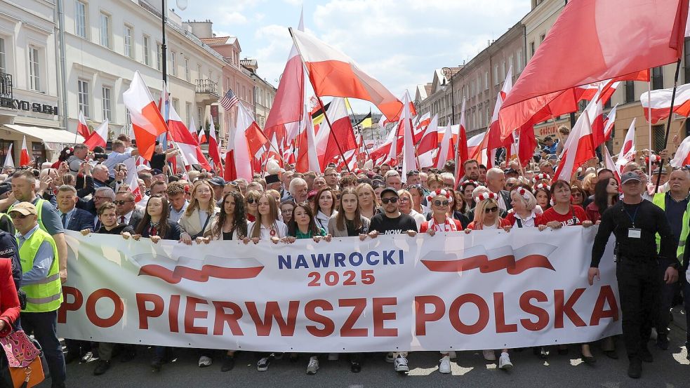 Anhänger des konservativen polnischen Präsidentschaftskandidaten Karol Nawrocki ziehen durch Warschau. (Foto aktuell) Foto: Albert Zawada/PAP/dpa