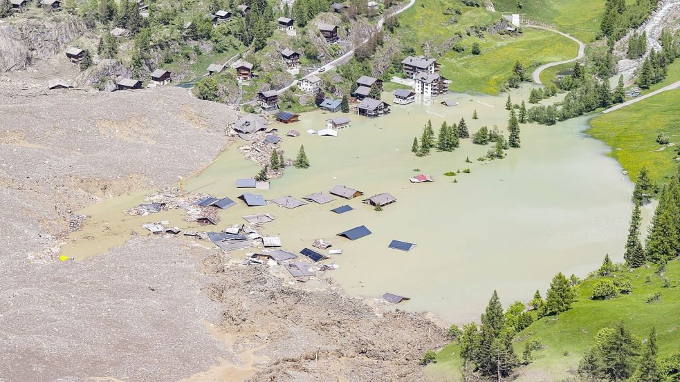 Das Wasser hat sich wegen des Schuttberges zu einem See gestaut. Foto: Jean-Christophe Bott/KEYSTONE/dpa
