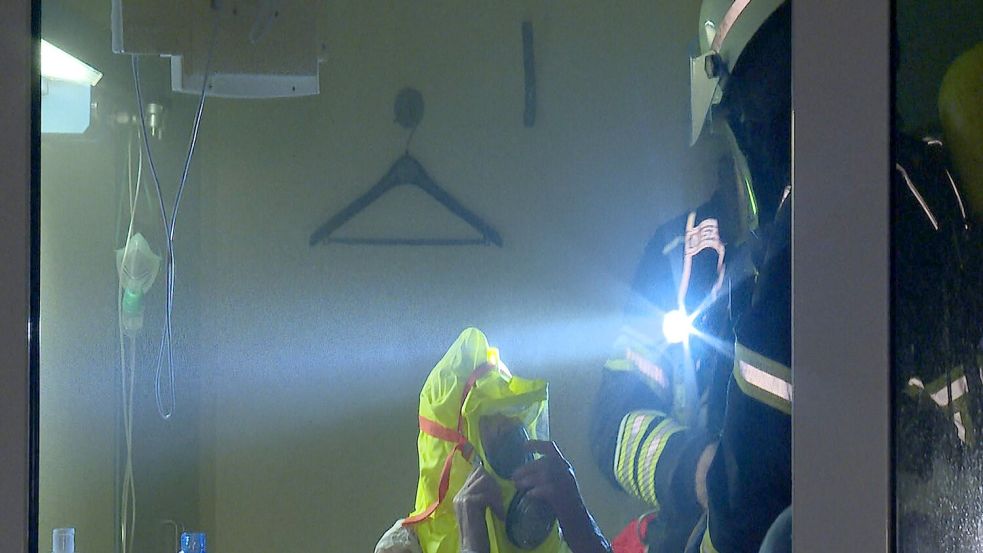 Ein Feuerwehrmann hilft einem Patienten in einem Zimmer des Krankenhauses. Foto: Steven Hutchings/dpa