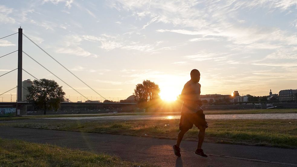 Ein Jogger in Düsseldorf: Auch Sport kann an extremen Hitzetagen gefährlich werden. Foto: Lukas Fortkord/dpa