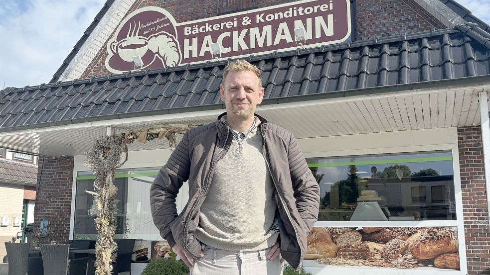 Inhaber Jan Becker steht vor seiner Bäckerei Hackmann in Idafehn. Während der Straßensperrung zwischen Wittensand und der Aral-Tankstelle bleibt das Geschäft zu – stattdessen bietet der 34-Jährige seine Waren in einem Verkaufswagen vor dem Rathaus an. Fotos: Henrik Zein