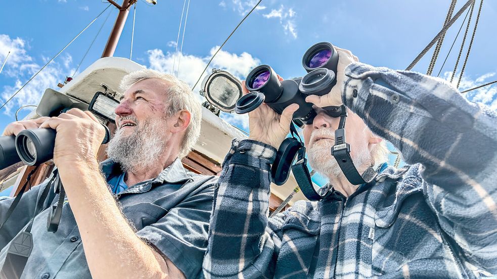 Bei der Kutterfahrt auf der Ems hat auch Nationalparkvogelführer Edzard Busemann (links) sein Fernglas allzeit bereit. Foto: Klaus Ortgies
