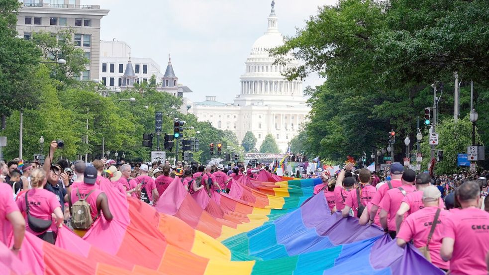 Mit riesigen Regenbogenfahnen demonstrieren Menschen mit Blick auf das US-Kapitol bei einer Pride-Parade in Washington für die Rechte der LGBTQI+-Gemeinschaft. Foto: Mark Schiefelbein/AP/dpa