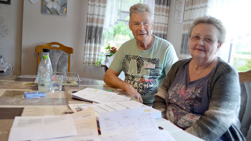 Lothar und Thekla Hoffmann an ihrem Küchentisch in Strücklingen-Utende vor einem Ordner voll Schriftverkehr mit der EWE. So viel Ärger wie in den vergangenen zwei Jahren habe sie mit dem Energieversorger in all den Jahren vorher nie erlebt, sagt Thekla Hoffmann. Sie ist froh, dass sie ihren Vertrag gekündigt hat und nun bald nichts mehr mit der EWE zu tun hat. Foto: Astrid Fertig