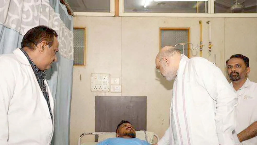 Das vom indischen Innenministerium herausgegebene Foto zeigt Innenminister Amit Shah bei einem Treffen mit dem Überlebenden des britischen Flugzeugabsturzes, Vishwash Kumar Ramesh, in einem Krankenhaus in Ahmedabad. Foto: Indian Ministry of Home Affairs/dpa