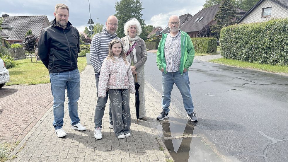 Die achtjährige Lotta (vorne) war vor einiger Zeit mit dem Fahrrad auf dem Fußweg, auf dem Radfahren erlaubt ist, entlang der Schulstraße in Collhusen unterwegs. Lotta geriet mit dem Vorderreifen in ein Loch und stürzte. Dabei brach sie sich einen Arm. Mit auf dem Foto zu sehen sind (von links) Lars Czimny (Interessengemeinschaft Verkehrssicherheit Schulstraße), Daniel Wessling, Vater von Lotta), sowie Hedwig Daute und Detlef Hermann, beide vom Ortsverband Overledingerland von Bündnis 90/Die Grünen. Foto: Carsten Ammermann