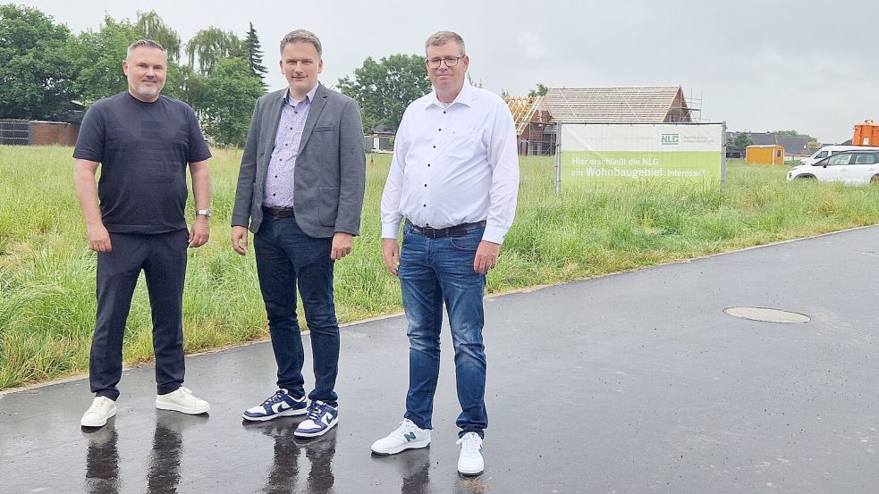 Wo heute noch eine grüne Wiese ist, wird in Wymeer demnächst eine C-Box entstehen. Projektmanager Marcus Jonashoff (von links), Bürgermeister Uwe Sap und Bünting-Expansionsleiter Nord, Matthias Adler, stellten die Pläne vor. Foto: Tatjana Gettkowski