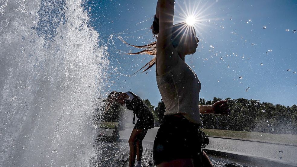 Temperaturen von annähernd 40 Grad in der Hauptstadt - diese Touristen nutzen einen Brunnen zur Abkühlung. Foto: Michael Kappeler/dpa