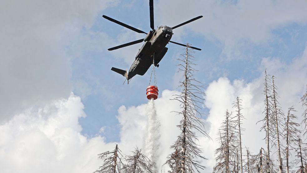 Hubschrauber im Löscheinsatz bei einem Waldbrand im Harz. Foto: Matthias Bein/dpa