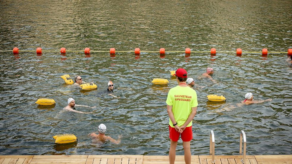 Für die Schwimmerinnen und Schwimmer in der Seine gibt es Umkleiden, Strandstühle und eine Badeaufsicht. Foto: Thomas Padilla/AP/dpa