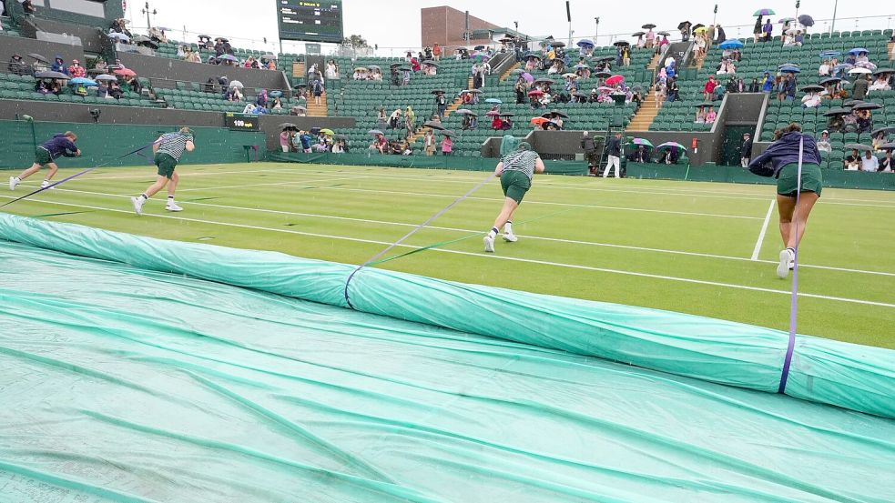 Zweimal muss der Platz während der Partie von Laura Siegemund abgedeckt werden. Foto: Kirsty Wigglesworth/AP/dpa