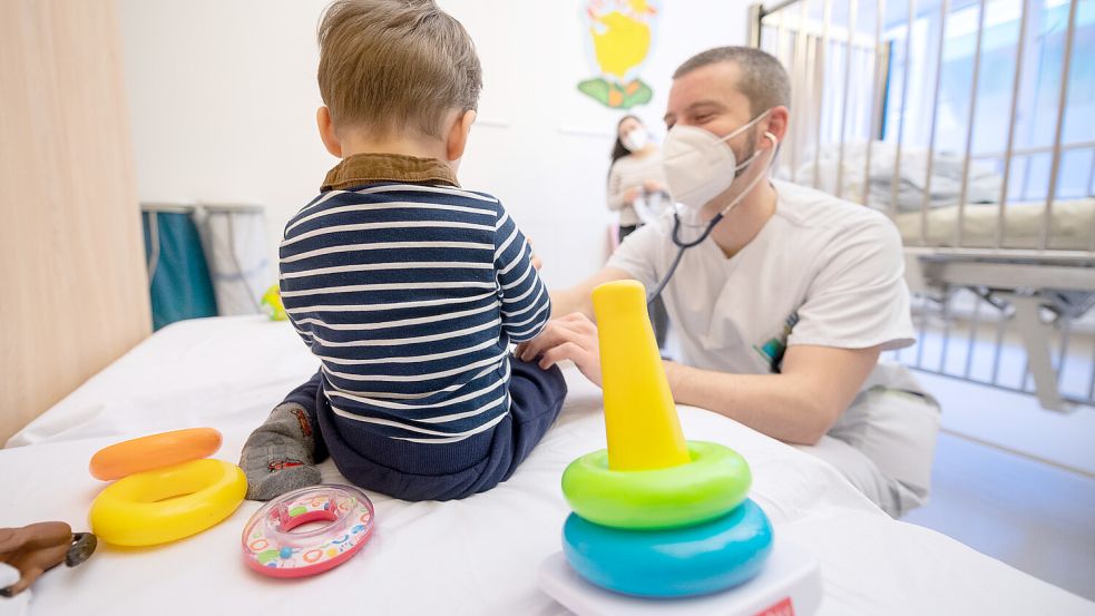 Ein Arzt untersucht in einer Kinderklinik ein Kind. Foto: Sebastian Gollnow/dpa