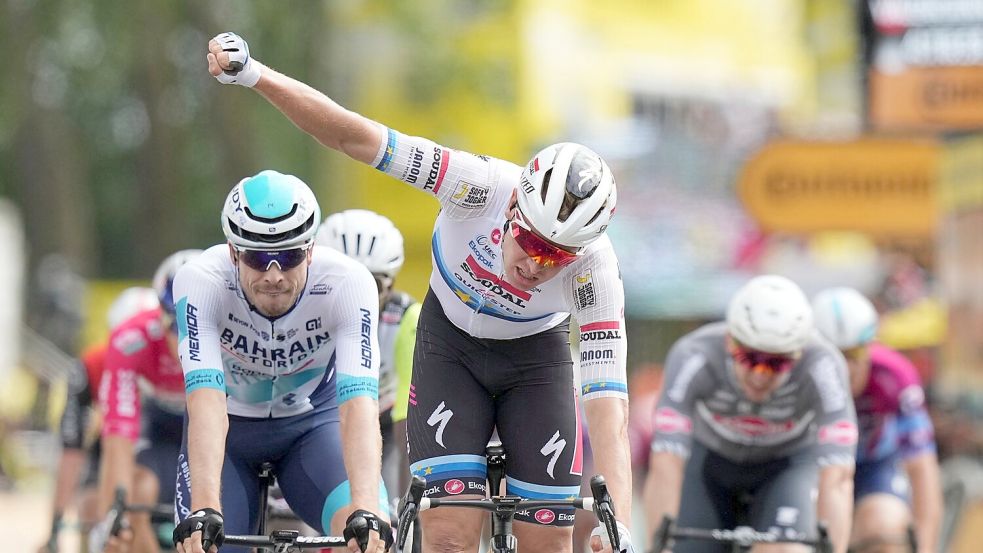 Tim Merlier feiert den Etappensieg, der deutsche Sprinter Phil Bauhaus (L.) freut sich über den dritten Rang. Foto: Thibault Camus/AP/dpa