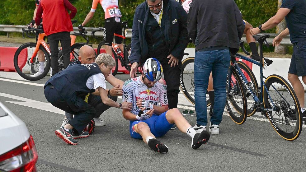 Jordi Meeus aus dem deutschen Red-Bull-Team wird medizinisch versorgt, nachdem er auf den letzten Kilometern vor dem Ziel der 3. Etappe gestürzt ist. Foto: Loic Venance/AFP/dpa