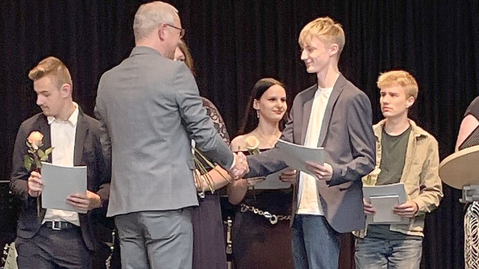Schulleiter Christian Hunsmann überreicht einem Schüler sein Abschlusszeugnis. Foto: privat